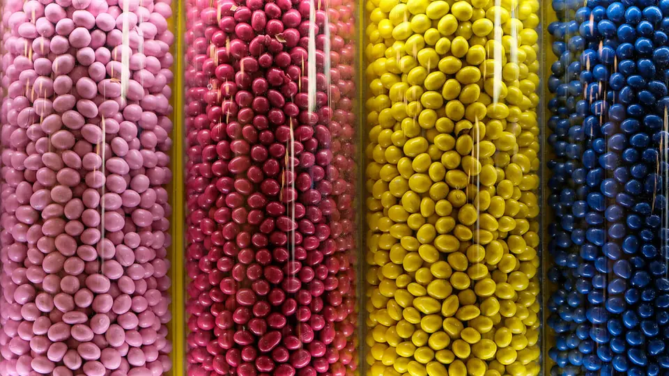 Potjes met roze, gele en blauwe suikerparels