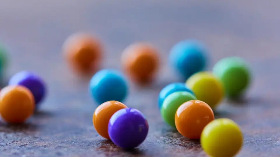 Kleine gekleurde snoepbolletjes op een grijs vlak