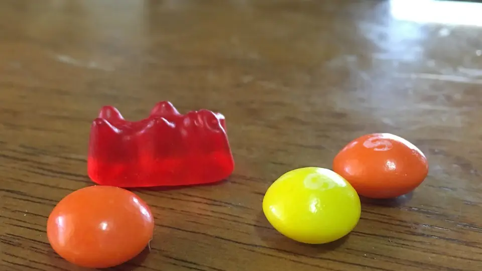 Rode gomsnoep en drie kauwsnoepjes op hout